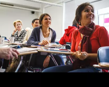 un groupe de femmes souriantes assises dans une salle