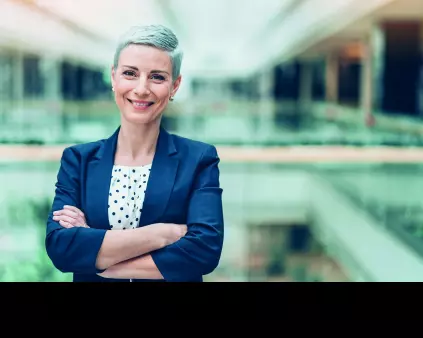 une femme cheveux gris croisant les bras dans une entreprise