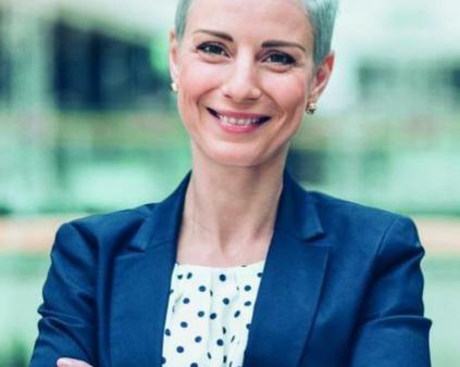 une femme cheveux gris croisant les bras dans une entreprise