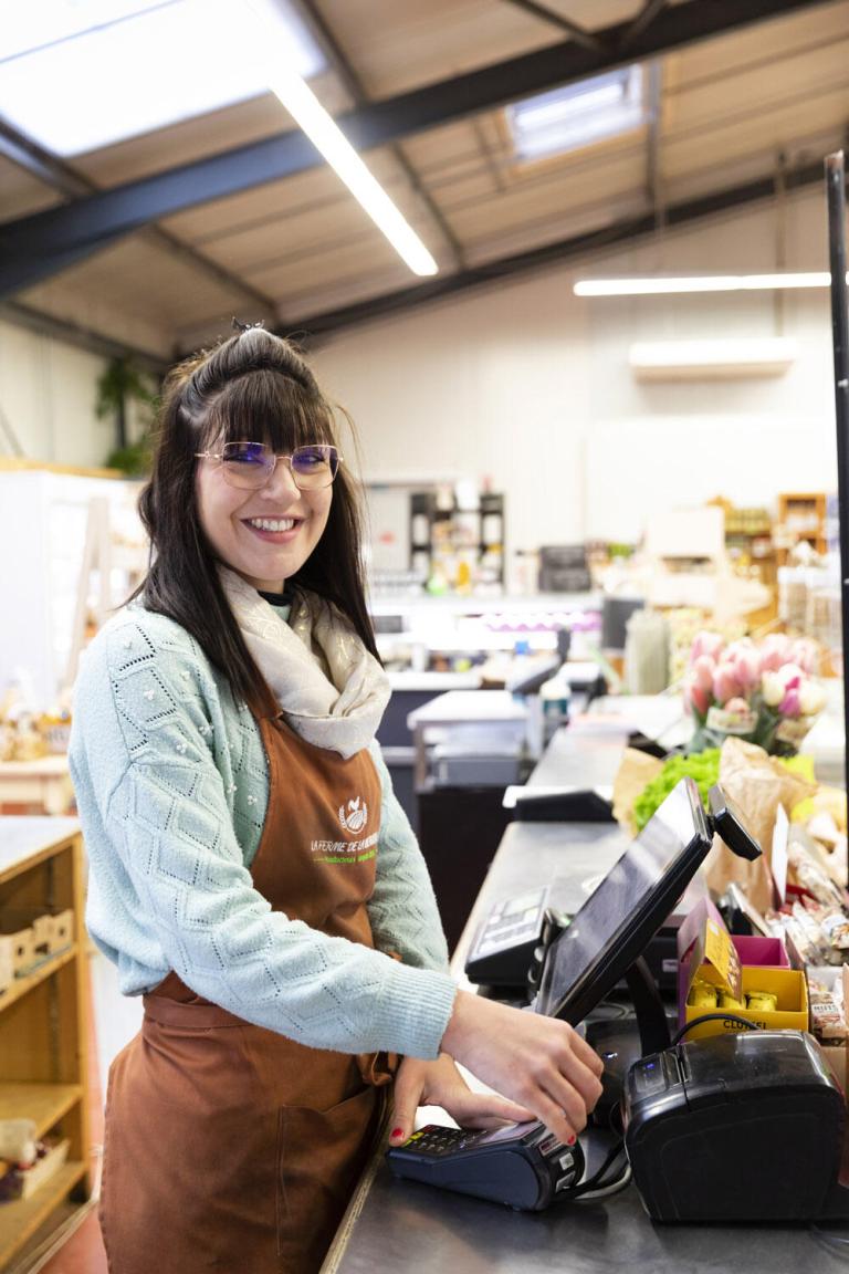 jeune femme à la caisse d'un magasin de producteurs