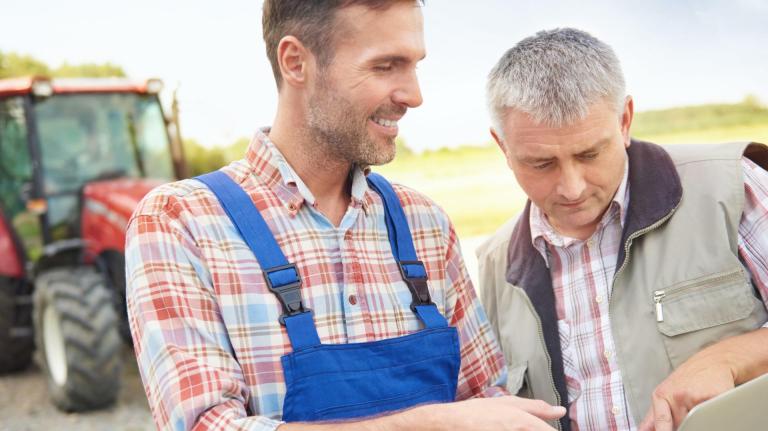 Deux agriculteurs consultant un ordinateur