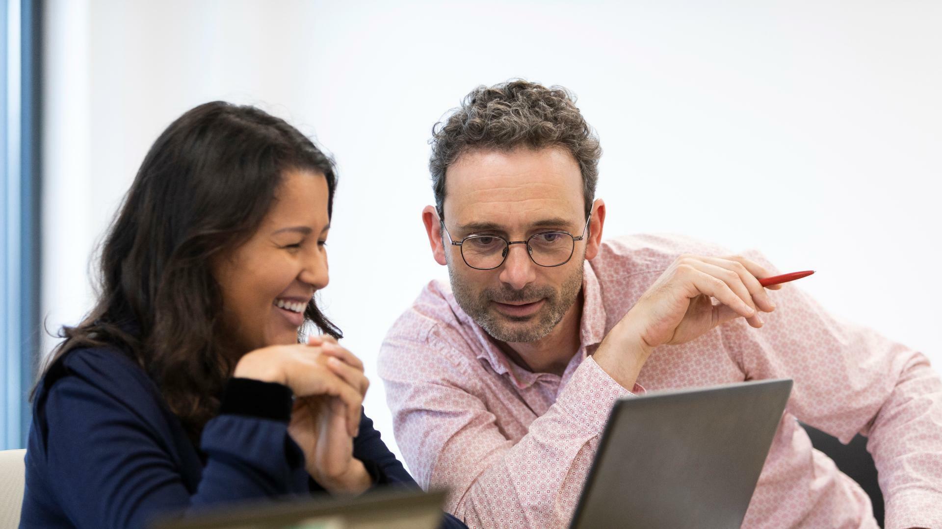 Une femme et un homme consultant un ordinateur