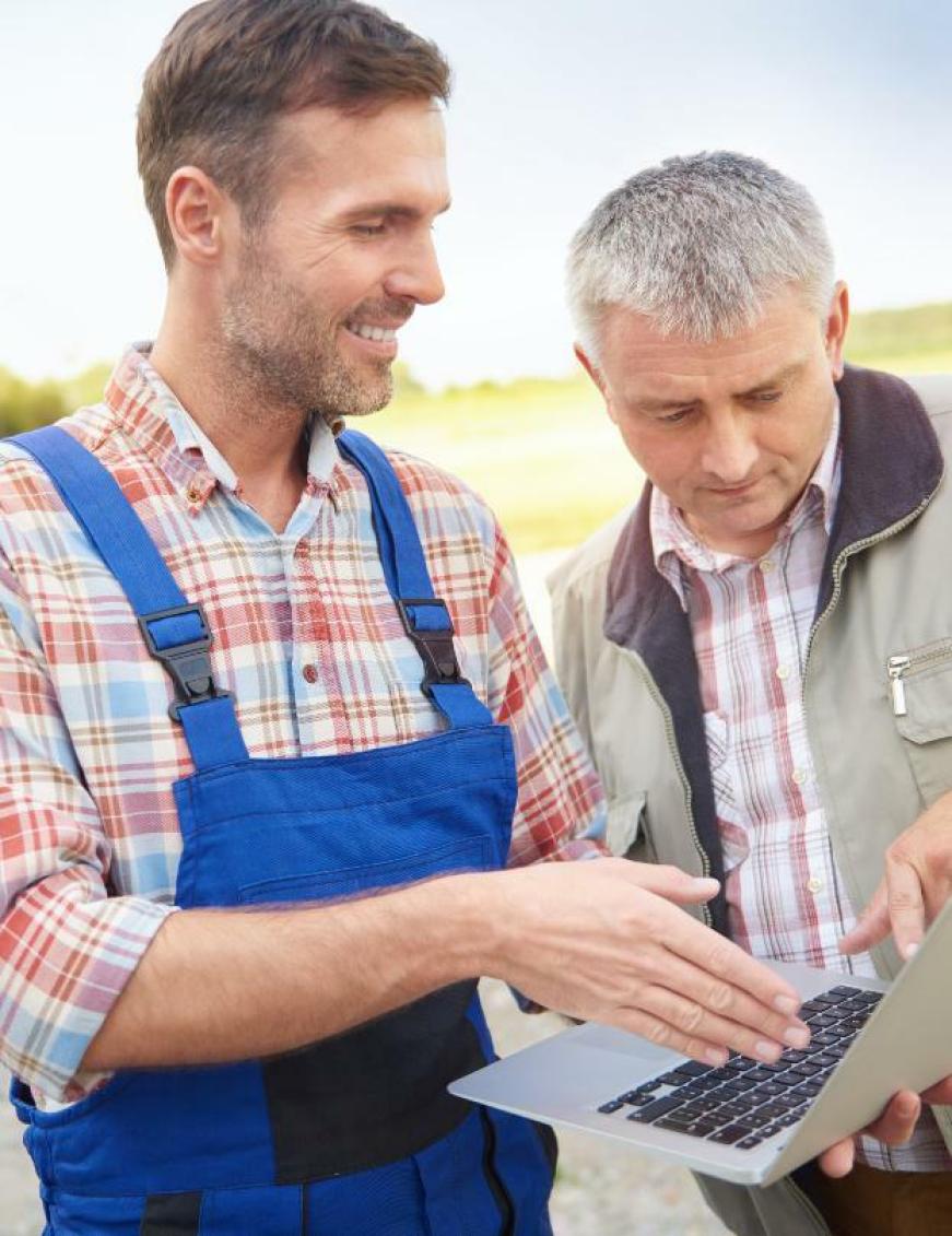 un agriculteur avec un ordi à la main et un conseillerun ordinate