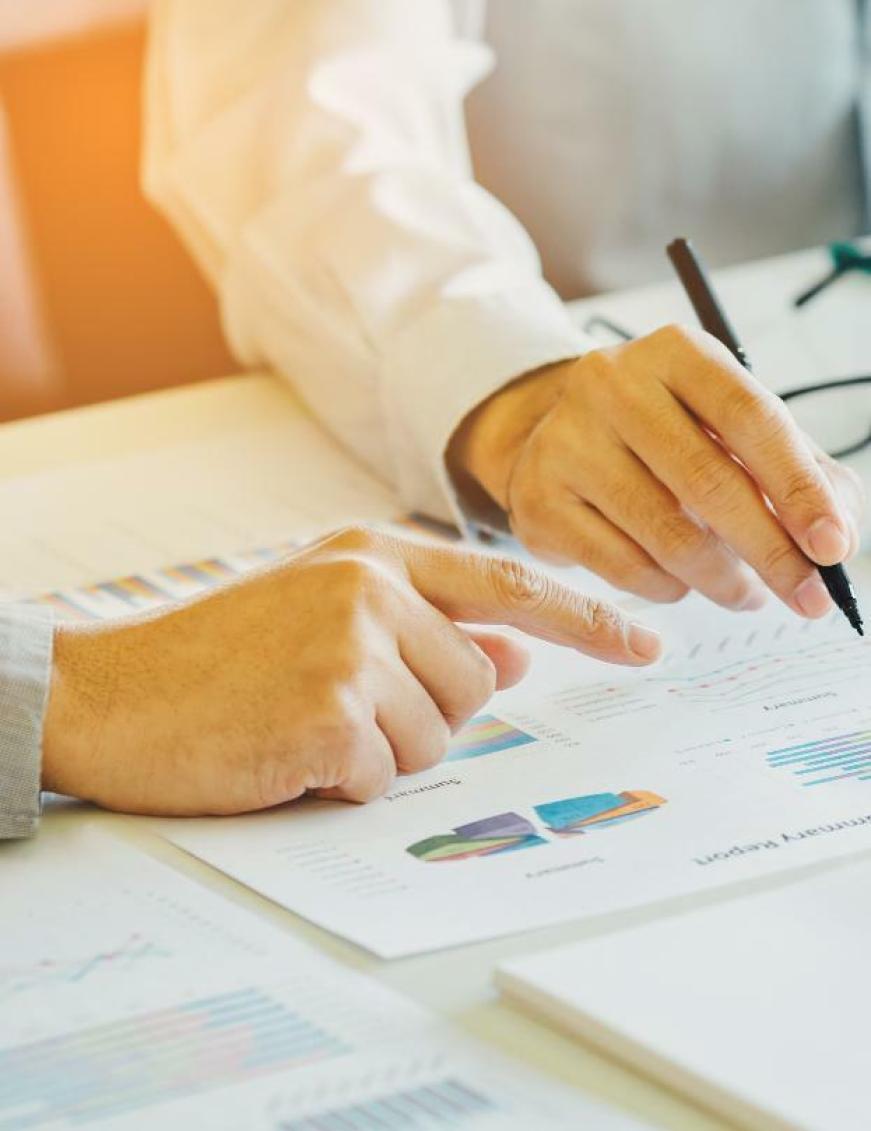 une main pointant un document avec graphiques