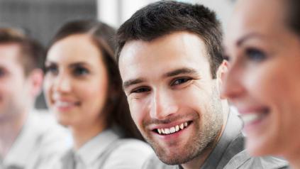 3 personnes de profil et 1 jeune homme de face souriant